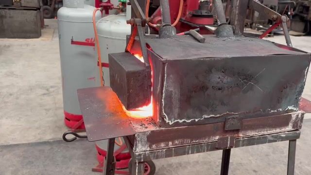 Molten metal glowing in a foundry furnace with red heating elements visible