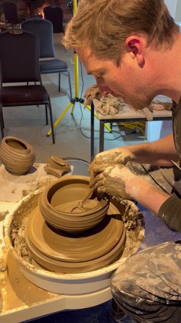 Hands throwing clay on a pottery wheel